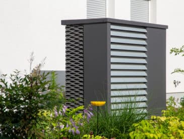 Moderne Wärmepumpe vor einem Wohnhaus