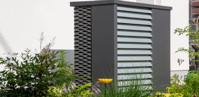 Moderne Wärmepumpe vor einem Wohnhaus